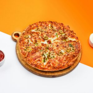 A flavorful pizza with green olives, accompanied by sauces on a vibrant backdrop.